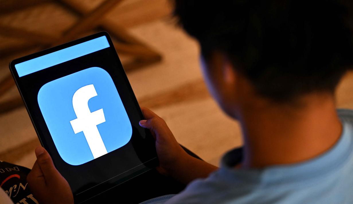 Kebijakan ini bertujuan untuk melindungi kesehatan mental anak-anak dari bahaya daring, perundungan siber, serta konten berbahaya. Tampak dalam foto, seorang anak laki-laki berusia 13 tahun berpose di rumahnya sambil melihat media sosial di tabletnya di Sydney, Australia pada Senin 8 Desember 2025. (Saeed KHAN/AFP)