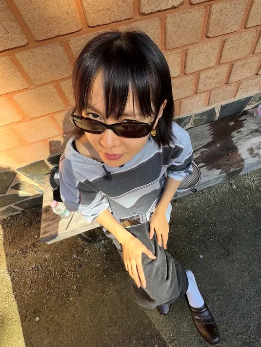 Ibu satu anak ini pun memilih menata poni dengan gaya poni depan panjang berjarak. Membuat tampilannya awet muda.  [@yejinhand]