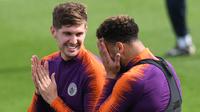 Bek Manchester City, John Stones berbincang dengan Kyle Walker selama sesi pelatihan tim di City Football Academy, Inggris (18/9). City akan bertanding melawan wakil Prancis, Lyon pada grup F Liga Champions. (AFP Photo/Oli Scarff)