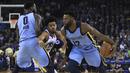 Pemain Memphis Grizzlies, Tyreke Evans (kanan) melewati adangan pemain Golden State Warriors, Quinn Cook (tengah) pada laga NBA basketball games di ORACLE Arena, Oakland (20/12/2017). Warriors menang 97-84. (AP/Ben Margot)