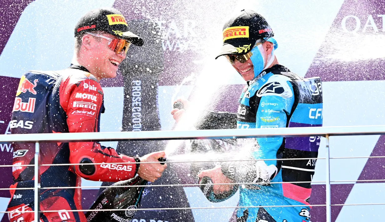 Pembalap CFMOTO Aspar Team, David Alonso (kanan) merayakan kemenangan di atas podium saat balapan Moto3 GP Australia 2024 di Philip Island, Australia, Minggu (20/10/2024). (AFP/William West)