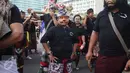 Seorang anak mengenakan topeng saat sosialisasi pawai ogoh-ogoh di kawasan CFD, Bundaran HI, Jakarta, Minggu (19/3). Pawai ogoh-ogoh akan diadakan secara besar di Pura Agung Wira Satya Bhuana, Jakarta, pada Senin (27/3). (Liputan6.com/Angga Yuniar)