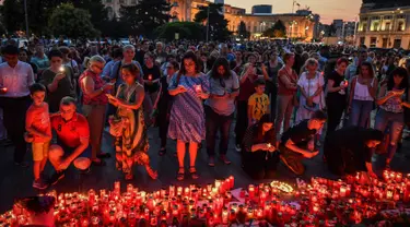 Warga menyalakan lilin untuk memperingati gadis berusia 15 tahun Alexandra yang terbunuh di depan Kementerian Dalam Negeri Rumania di Bucharest (27/7/2019). Alexandra diculik pada Rabu (24/7) ketika ia menumpang pulang ke Dobrosloveni di Rumania selatan, kata polisi.  (AFP Photo/Daniel Mihailescu)