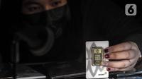 Petugas menunjukkan koleksi lempengan emas di Pegadaian, Jakarta, Selasa (18/5/2021). Berdasarkan informasi dari Unit Bisnis Pengolahan dan Pemurnian Logam Mulia Antam, harga dasar emas 24 karat ukuran 1 gram dijual Rp 937.000, naik Rp 4.000 per gram dari harga sebelumnya. (Liputan6.com/Johan Tallo)