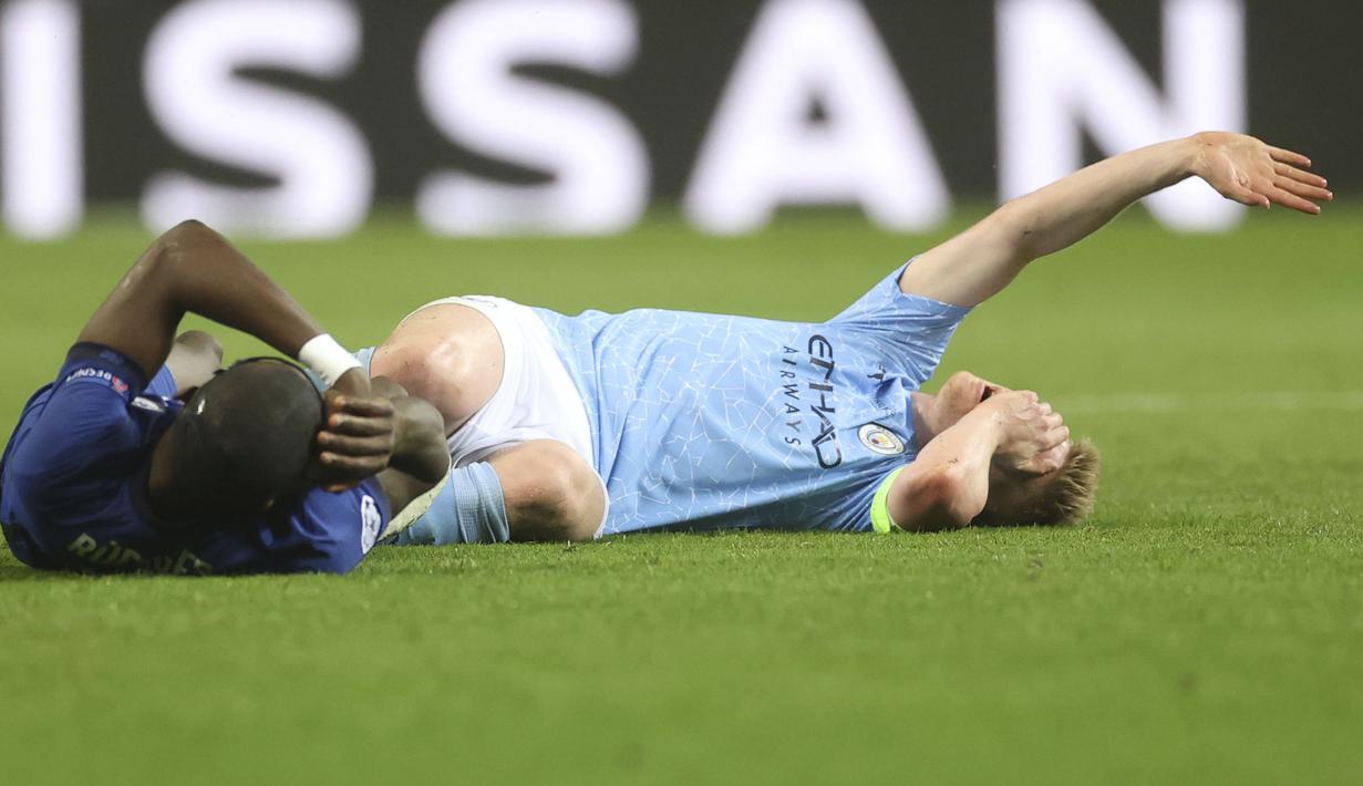 Antonio Rudiger (kiri) dan Kevin De Bruyne (kanan) terjatuh setelah bertabrakan selama pertandingan final Liga Champions antara Manchester City dan Chelsea di Stadion Dragao di Porto, Portugal, Sabtu, (29/052021) atau Minggu dini hari WIB. (Foto: AP/Pool/Carl Recine)