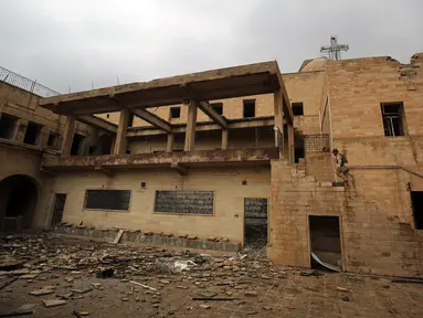 Seorang tentara Irak memeriksa Gereja St. George Monastery (Mar Guguis) yang rusak parah di Mosul, 22 Januari 2017. Salah satu gereja bersejarah di Irak tersebut tak luput dari pengerusakan yang dilakukan kelompok radikal ISIS. (AHMAD AL-RUBAYE/AFP)