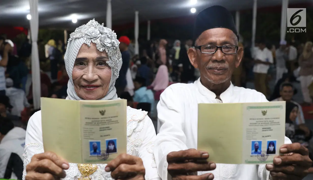 Pasangan nikah massal menunjukkan buku nikah usai ijab kabul di jalan MH Thamrin, Jakarta, Senin (31/12). 557 pasangan mengikuti nikah massal dan isbat nikah pada malam pergantian tahun 2018-2019. (Liputan6.com/Helmi Fithriansyah)