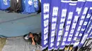 Seorang pedagang atribut santai menunggu pembeli dagangannya di Stadion Si Jalak Harupat, Bandung, Sabtu (24/10/2015). (Bola.com / Nicklas Hanoatubun)