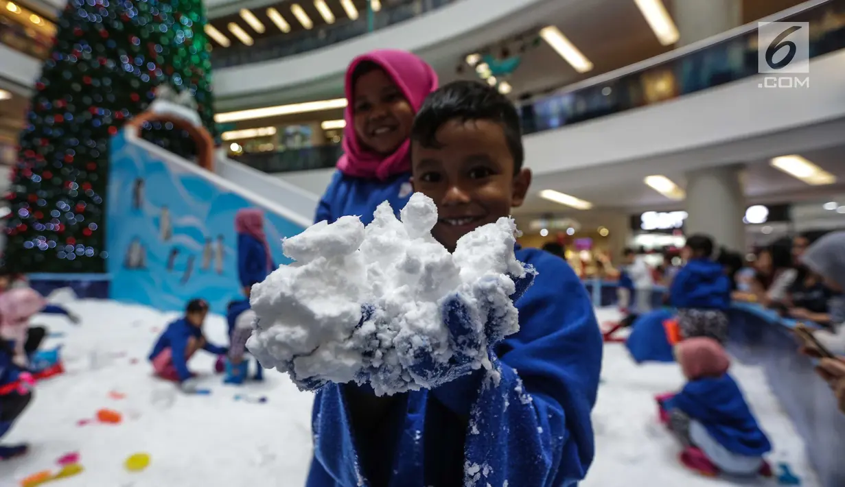 Seorang anak menunjukkan salju saat bermain Snow Playland di Mall Ciputra, Jakarta barat, Selasa (19/12). Mengusung tema It’s Christmas Time, serangkaian acara bernuansa natal disuguhkan untuk menghibur pengunjung. (Liputan6.com/Faizal Fanani)