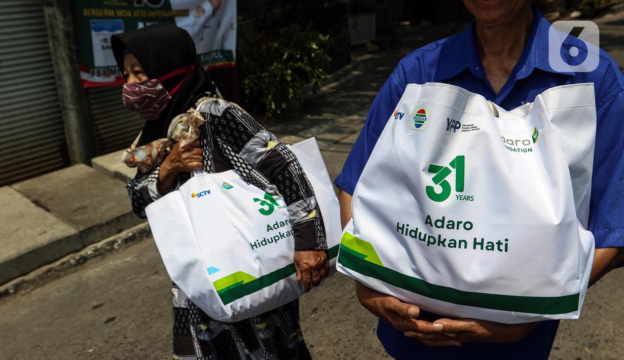 Warga membawa sembako yang di bagikan oleh PT Adaro Energi Tbk bersama Yayasan Pundi Amal Peduli Kasih (YPP) SCTV dan Indosiar di Jakarta, Rabu (4/10/2023). Dalam rangka Hari Ulang Tahun (HUT) Adaro ke-31 dengan tema “Adaro Hidupkan Hati” membagikan sembako sebanyak 2.000 paket  kepada masyarakat yang betul-betul memerlukan yang saat ini kurang beruntung di tengah beberapa harga sembako yang alami kenaikan. (Liputan6.com/Angga Yuniar)