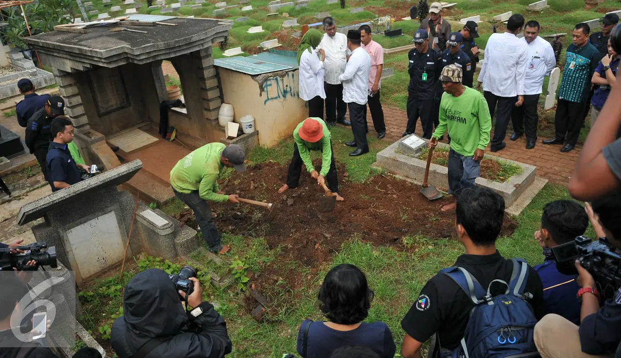 Suasana pembongkaran makam fiktif di Tempat Pemakaman Umum (TPU) Menteng Pulo, Jakarta Selatan, Kamis (28/7). 4 makam dari total terindikasi 14 makam fiktif ditemukan di TPU tersebut. (Liputan6.com/Gempur M Surya)