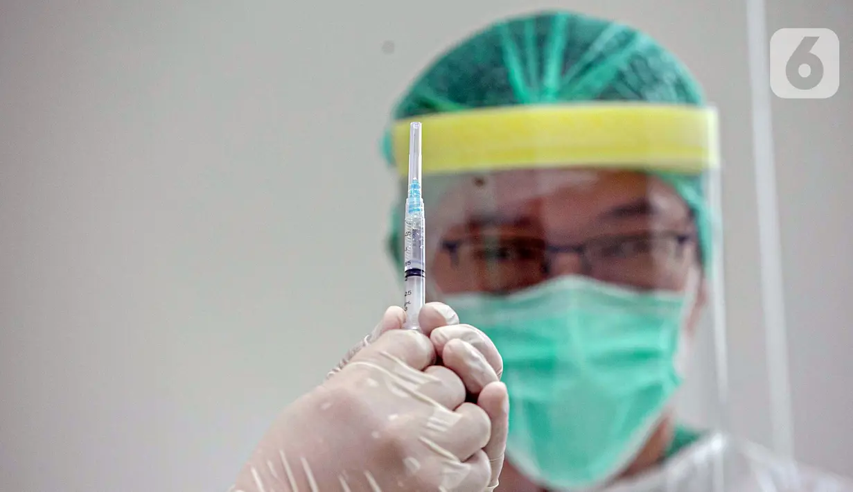 Vaksinator memeriksa jarum suntik sebelum melakukan vaksinasi COVID-19 kepada Wakil Menteri Kesehatan Dante Saksono Harbuwono di RSCM, Jakarta, Kamis (14/1/2021). Menurut Menteri Kesehatan Budi Gunadi Sadikin, tahap awal program vaksinasi akan menyasar tenaga kesehatan. (Liputan6.com/Faizal Fanani)