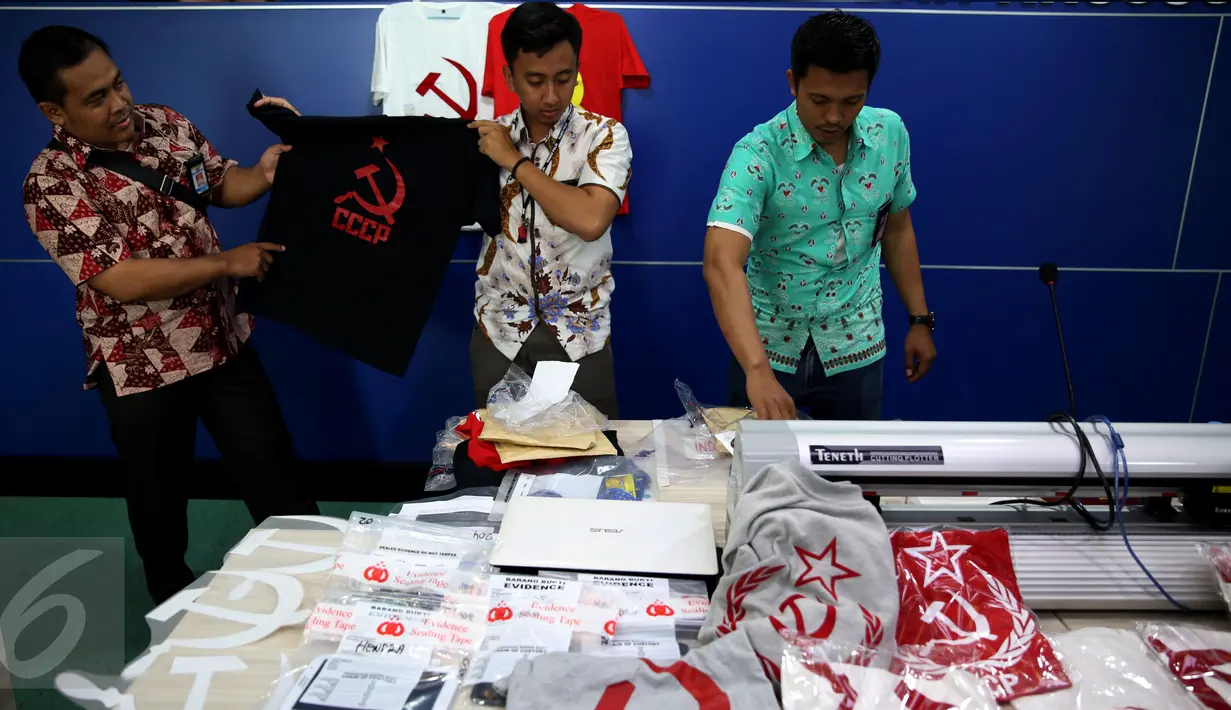 Petugas menunjukkan barang bukti saat rilis penangkapan tersangka penjual kaus berlogo palu arit secara online di Bareskrim Polri, Jakarta, Jumat (30/12). HS ditangkap karena dianggap menyebarkan paham komunisme dan marxisme (Liputan6.com/Johan Tallo)