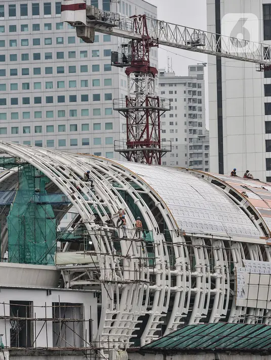 Aktivitas pekerja menyelesaikan pembangunan stasiun kereta Light Rail Transit (LRT) Dukuh Atas, Jakarta, Rabu (17/2/2021). Stasiun Dukuh Atas bakal menjadi hub transportasi Jakarta, atau titik di mana warga dari berbagai asal memilih dan berganti moda transportasi. (merdeka.com/Iqbal S Nugroho)