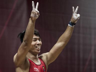 Lifter Indonesia, Deni, menyapa suporter saat berlaga pada Asian Games di JIExpo, Jakarta, Rabu (22/8/2018). Deni memastikan lolos ke final setelah berhasil membukukan poin terbaik dengan total angkatan seberat 318 kg. (Bola.com/Vitalis Yogi Trisna)