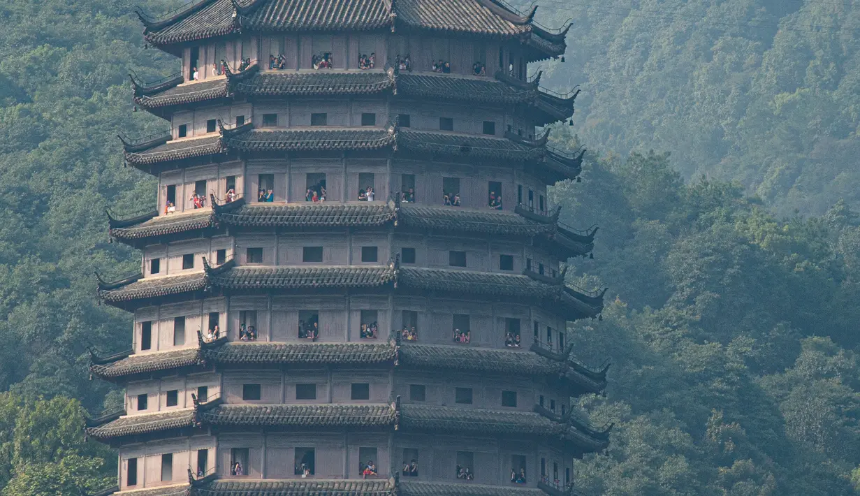 Warga menyaksikan gelombang pasang Sungai Qiantang dari Pagoda Liuhe di sepanjang sungai tersebut, Hangzhou, Provinsi Zhejiang, China, 4 Oktober 2020. Gelombang pasang Sungai Qiantang terjadi bertepatan dengan libur Hari Nasional dan Festival Pertengahan Musim Gugur tahun ini. (Xinhua/Jiang Han)