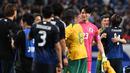 Pemain Jepang, Ko Itakura berpelukan dengan pemain Australia saat laga lanjutan Grup C Kualifikasi Piala Dunia 2026 di Saitama Stadium, Jepang, Selasa (15/10/2024). (AFP/Philip Fong)