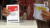 Warga memasukkan surat suata saat simulasi pemungutan suara Pemilu 2024 di Halaman Kantor Wali Kota Jakarta Pusat, Rabu (17/1/2024). (Liputan6.com/Herman Zakharia)