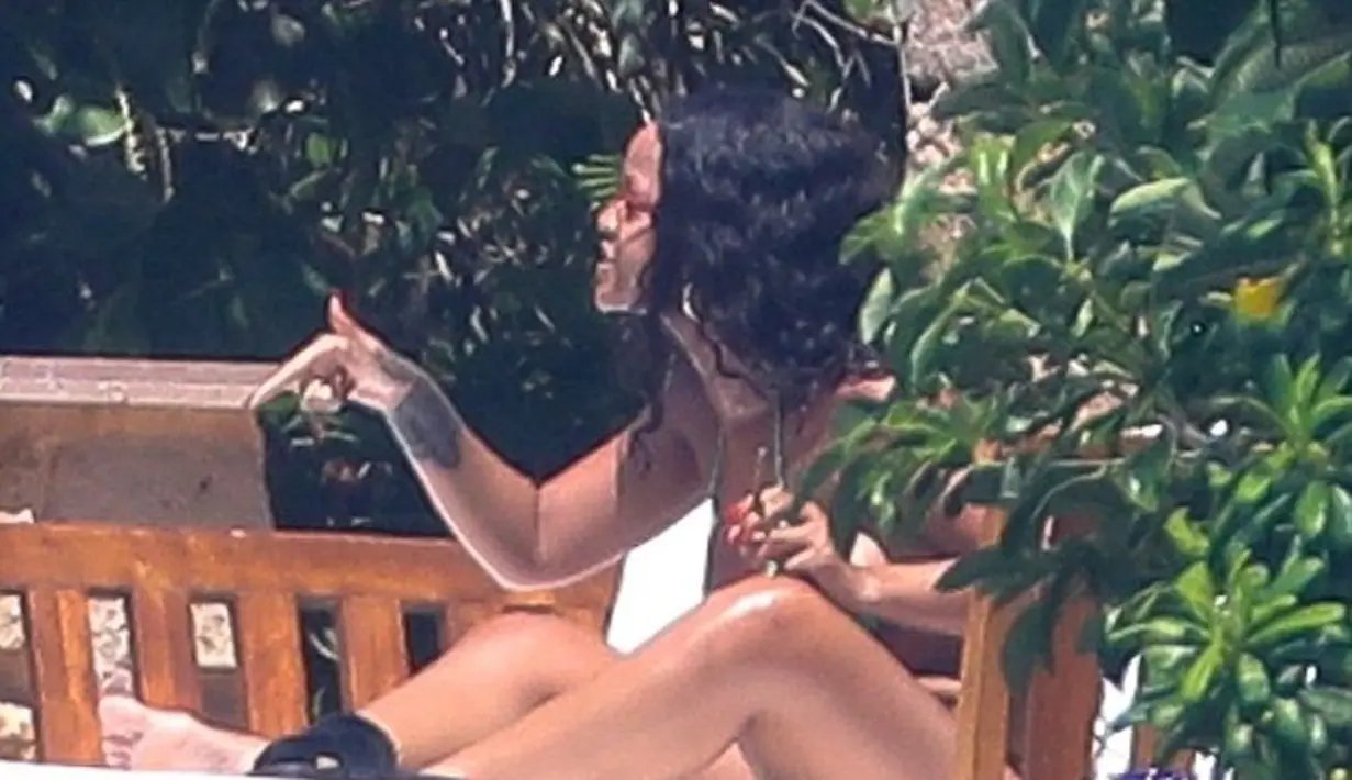 Dalam sebuah foto, Rihanna menaikan telunjuknya dan bicara pada Hassan Jameel. (HEM-BACKGRID-DailyMail)