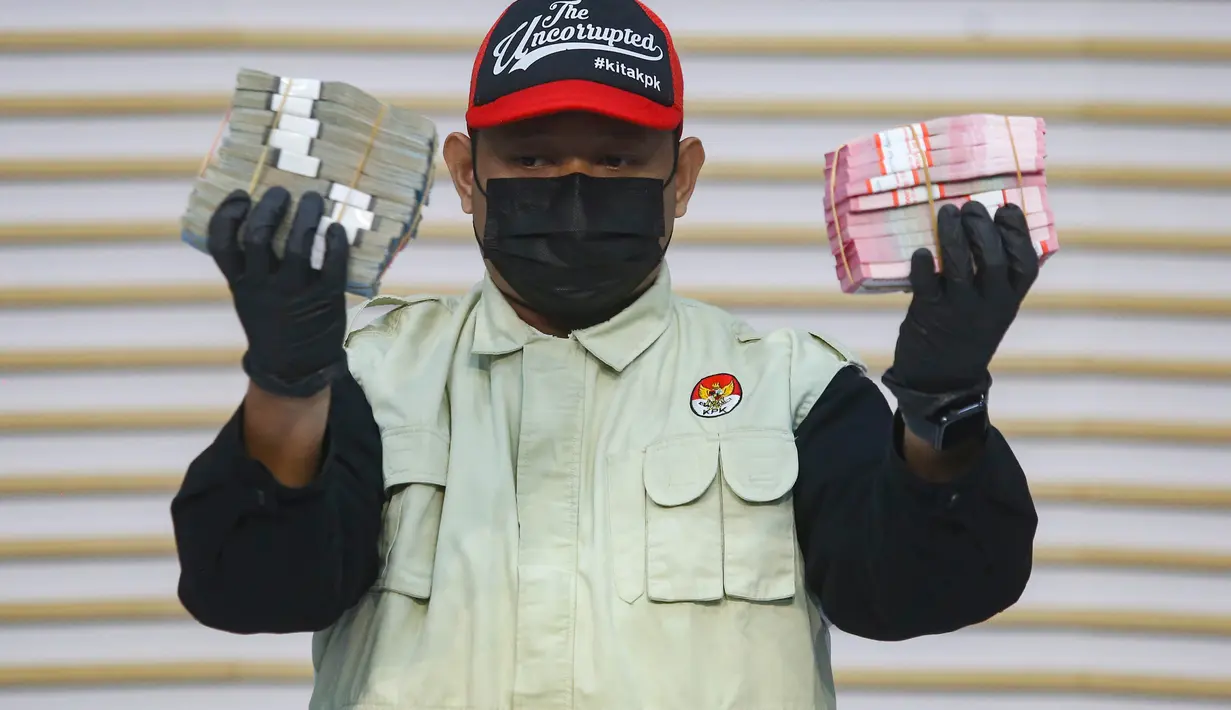 Petugas menunjukkan barang bukti uang hasil OTT Bupati Lombok Barat Lalu Ahmad Zaini di Gedung Merah Putih KPK, Jakarta, Selasa (21/7/2026). (KLY/Arie Basuki)