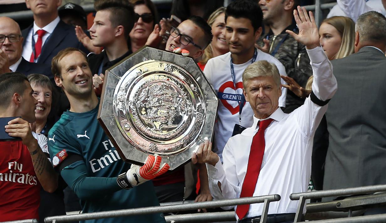 Pelatih Arsenal, Arsene Wenger, bersama kiper Petr Cech, mengangkat trofi Community Shield usai mengalahkan Chelsea di Stadion Wembley, London, Minggu (6/8/2017). Ini merupakan trofi Community Shield yang ke-15 bagi Arsenal. (AFP/Ian Kington)