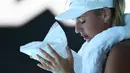 Petenis Ukraina Marta Kostyuk mendinginkan diri menggunakan kompres es saat bermain melawan petenis Spanyol Paula Badosa pada pertandingan tunggal putri turnamen tenis Australian Open di Melbourne, Australia, 21 Januari 2022. (William WEST/AFP)