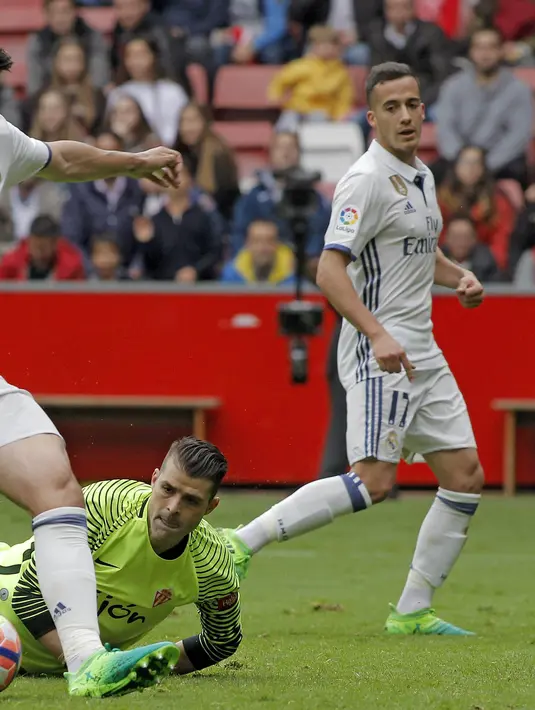 Pemain Real Madrid, Alvaro Morata (tengah) berusaha mengecoh kiper Sporting de Gijon, Ivan Cuellar 'Pichu' pada lanjutan La Liga di El Molinon Stadium, Gijon,(15/42017). Real Madrid menang 3-2. (EPA/Alberto Morante)