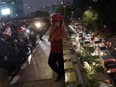 Warga melihat kendaraan yang terjebak kemacetan di sekitar kawasan Pejompongan akibat unjuk rasa mahasiswa di depan Gedung DPR, Jakarta, Selasa (24/9/2019). Demonstrasi mahasiswa dilakukan untuk menolak pengesahan berbagai RUU yang dianggap bermasalah. (Liputan6.com/Helmi Fithriansyah)