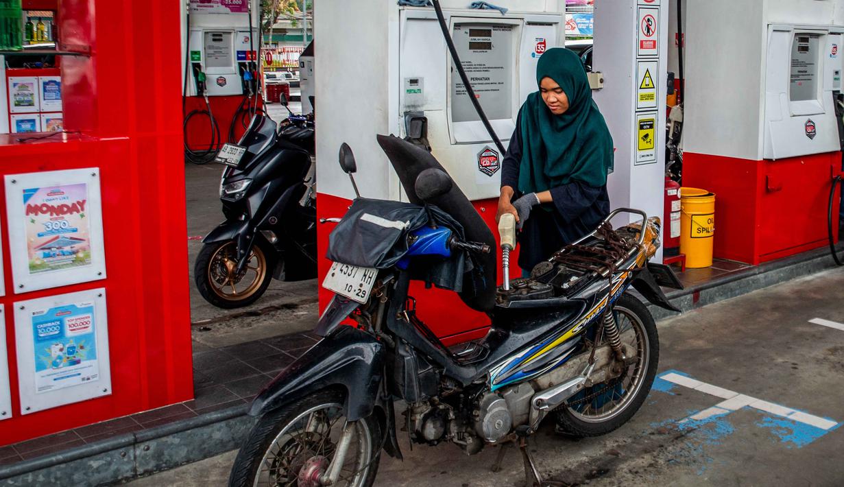 Seorang pengendara sepeda motor mengisi bahan bakar motornya di sebuah Stasiun Pengisian Bahan Bakar Umum (SPBU) yang dioperasikan oleh Pertamina, perusahaan minyak dan gas milik negara Indonesia, di Yogyakarta, pada Sabtu 28 Maret 2026. Konflik antara Iran dengan Amerika Serikat–Israel serta pembatasan di jalur strategis Selat Hormuz berdampak pada lonjakan harga minyak global. (DEVI RAHMAN/AFP)