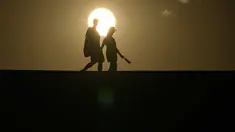 Marko Leszczuk berjalan di sepanjang dataran garam di Badwater Basin saat matahari terbenamdi Taman Nasional Death Valley, California, Minggu, 16 Juli 2023. Leszczuk, yang baru saja melakukan snorkeling dan membawa perlengkapannya di dalam truknya, memutuskan untuk bercanda dengan memakainya. (AP Photo/John Locher)