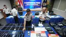 Petugas Imigrasi mengatur barang bukti yang disita dari warga negara Jepang yang diduga terlibat dalam sindikat penipuan daring (online), di Bogor, Jawa Barat, Rabu 4 Maret 2026. 13 warga negara asing atau WNA asal Jepang ditangkap petugas Kantor Imigrasi Bogor, Jawa Barat. (AP Photo/Achmad Ibrahim)