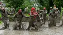 Para petani berlumur lumpur saat bermain pada Hari Padi Nasional di sawah Desa Tokha, Kathmandu, Nepal, Senin (29/6/2020). Para petani di Nepal merayakan Hari Padi Nasional sebagai musim tanam padi tahunan dimulai. (PRAKASH MATHEMA/AFP)