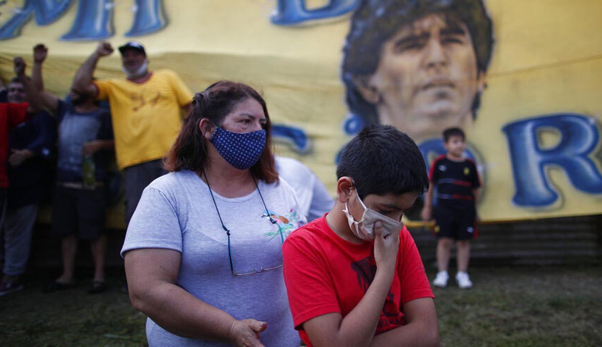 Seorang fans cilik tampak sedih usai meninggalnya Diego Maradona di Buenos Aires, Argentina, Rabu (25/11/2020). legenda sepak bola Argentina itu meninggal dunia pada usia 60 tahun setelah menderita serangan jantung. (AP/Natacha Pisarenko)