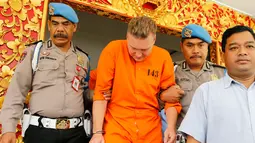 Polisi mengawal tersangka kasus narkoba asal Australia, David van Iersel, menuju lokasi konferensi pers di Mapolresta Denpasar, Bali, Selasa (23/7/2019). David ditangkap bersama rekannya, Wiliam Cabantog, di sebuah tempat hiburan di Badung, Bali, Jumat, 19 Juli 2019. (AP Photo/Firdia Lisnawati)