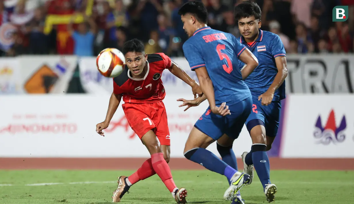 <p>Gelandang Timnas Indonesia U-22, Marselino Ferdinan (kiri) berusaha melewati pemain Thailand, Songchai Thongcham pada laga final cabor sepak bola SEA Games 2023 di National Olympic Stadium, Phnom Penh, Kamboja, Selasa (16/5/2023). (Bola.com/Abdul Aziz)</p>