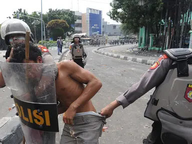 Anggota Sabhara Polri menangkap pengunjuk rasa saat bentrok  dengan massa aksi 22 Mei sebelum terjadi pembakaran bis milik Brimob di kawasan Tanah Abang,  Jakarta, Rabu (22/5/2019). (merdeka.com/Arie Basuki)