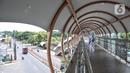 Pejalan kaki menggunakan fasilitas jembatan penyeberangan orang (JPO) di Jalan Kolonel Sugiono, Duren Sawit, Jakarta Timur, Senin (7/2/2022). JPO Kolonel Sugiono yang berada dekat Kanal Banjir Timur itu didesain dengan bentuk yang modern namun sarat kearifan lokal. (merdeka.com/Iqbal S Nugroho)