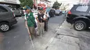 Penyandang disabilitas melintas di samping trotoar saat kampanye Bulan Patuh Pedestrian, Jakarta, Rabu (30/8). Kampanye dilakukan untuk memantau fasilitas akses pejalan kaki untuk disabilitas yang masih kurang layak. (Liputan6.com/Immanuel Antonius)