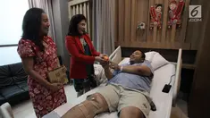 Kepala Divisi Pengembangan Bisnis RS Siloam Triana Tambunan (kiri) bersama Dokter RS Siloam Susilawati (kanan) memberikan jeruk pada pasien di RS Siloam, Semanggi, Jakarta, Kamis (15/2).  Hal ini dalam rangka merayakan Imlek. (Liputan6.com/Arya Manggala)