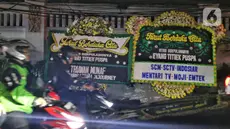 Deretan karangan bunga ucapan turut berduka cita terpampang di sepanjang jalan depan rumah duka penyanyi legendaris, Titiek Puspa di kawasan Pancoran, Jakarta Selatan, pada Kamis (10/4/2025) malam. (Liputan6.com/Angga Yuniar)