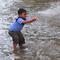 Seorang anak bemain air banjir yang merendam Jalan Benteng,  Duta Kranji, Kalibaru, Bekasi, Jawa Barat, Jumat (24/2/2023). Hujan yang turun di Bekasi sejak Kamis malam mengakibatkan sejumlah wilayah di Bekasi tergenang hingga lebih dari 50 cm. (merdeka.com/Imam Buhori)
