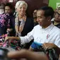 Presiden Joko Widodo (Jokowi) mengajak Direktur Pelaksana IMF Christine Lagarde memilih batik saat mengunjungi  Blok A Pasar Tanah Abang, Jakarta, Senin (26/2). Keduanya meninjau beberapa kios sambil berbincang dengan penjual. (Liputan6.com/Angga Yuniar)