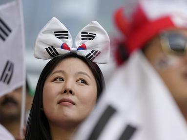 Suporter wanita dengan memakai aksesoris berupa ikat kepala memberikan dukungan kepadaTimnas Korea Selatan dalam pertandingan perdana Grup H Piala Dunia 2022 melawan Timnas Uruguay di Education City Stadium, Qatar, Kamis (24/22/2022). (AP Photo/Alessandra Tarantino)
