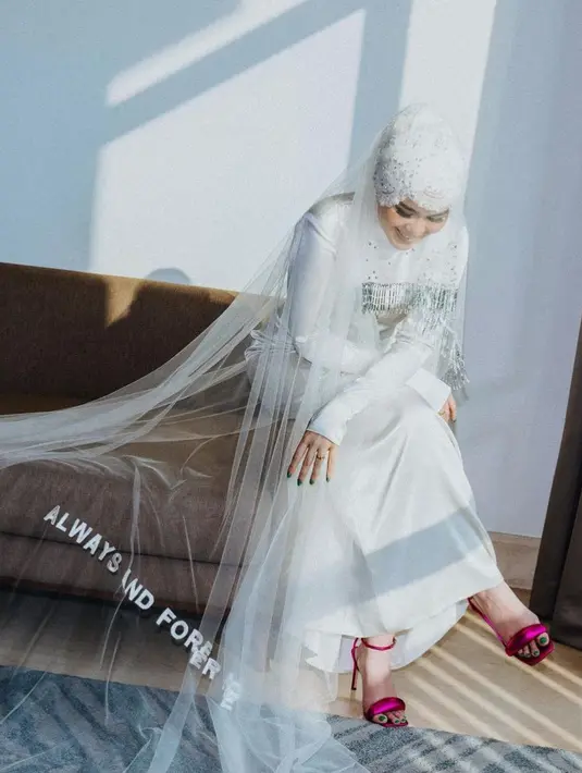 Sivia Azizah jiga tampil dengan veil berbordir bertuliskan Always And Forever More di atas kerudung berbordir dan gaun lengan panjangnya. [@siviazizah]