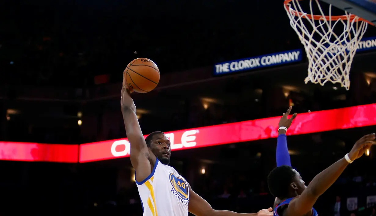Pebasket Golden State Warriors Harrison Barnes melakukan Dunk saat dibayangi pebasket Detroit Pistons Reggie Jackson di ORACLE Arena, California, Senin (9/11/2015). Warriors menang 109-95. (Getty Images/AFP/Ezra Shaw)