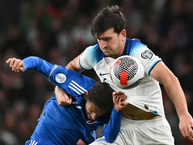 Pemain Timnas Inggris, Harry Maguire (kanan), berebut bola dengan pemain Timnas Italia, Domenico Berardi dalam laga lanjutan Kualifikasi Euro 2024 yang digelar di Wembley, London pada Rabu (18/10/2023) dini hari WIB. (AFP/Glyn Kirk)