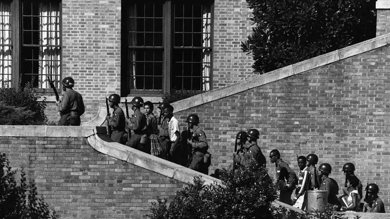 Sembilan siswa dikawal pasukan bersenjata memasuki Central High School di Little Rock, Arkansas, Amerika Serikat
