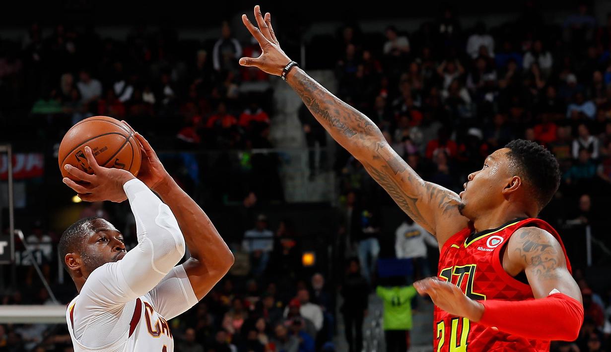 Pebasket Cleveland Cavaliers, Dwyane Wade, dihalangi oleh pebasket Atlanta Hawks, Kent Bazemore, saat akan shooting pada laga NBA di Philips Arena, Atlanta, Kamis (30/11/2017). Hawks kalah 114-121 dari Cavaliers. (AP/Kevin C. Cox)