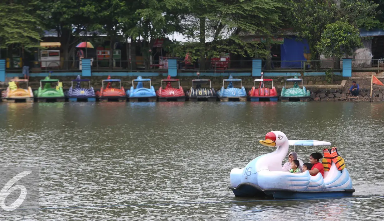 Warga menaiki perahu bebek di Setu Babakan, Jakarta, Jumat (25/11). Gubernur non-aktif DKI Jakarta Basuki Tjahaja Purnama memfokuskan dana pelestarian budaya Betawi di Unit Pelayanan Terpadu (UPT) Setu Babakan. (Liputan6.com/Immanuel Antonius)