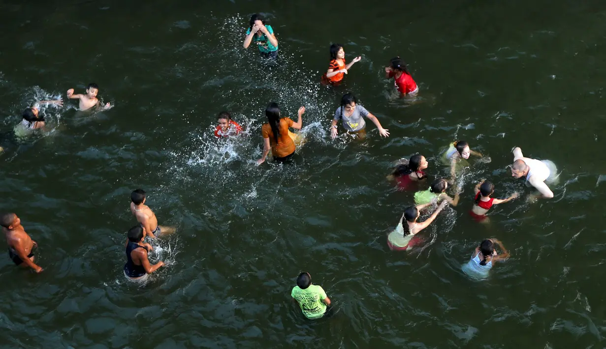 Sejumlah warga berenang untuk mendinginkan badannya akibat gelombang panas yang menimpa Kairo, Mesir, Rabu  (12/8/2015). Suhu di negara itu dilaporkan melonjak sampai 47 derajat Celcius. (REUTERS/Mohamed Abd El Ghany)